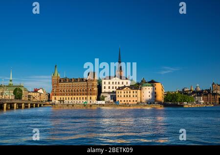 Riddarholmen island district with Riddarholm Church spires and typical sweden colorful gothic buildings near Lake Malaren water from Kungsholmen with Stock Photo