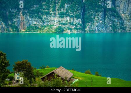 Village house in front of the Lake Walensee and the mountain chain of the Churfirsten Leistchamm, landscape in the Canton St. Gallen, Switzerland Stock Photo