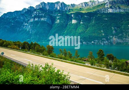 Top view of asphalt road and village houses in front of the Lake Walensee and mountain chain of Churfirsten Leistchamm, landscape in the Canton St. Ga Stock Photo