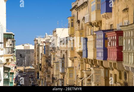 Top view of narrow streets and yellow buildings with colorful balconies and windows in Valletta, Malta Stock Photo