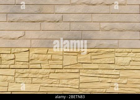 Cladding wall made of natural stone panels in pastel colors. Coverage for exterior design of building in closeup with your place for text. Stock Photo
