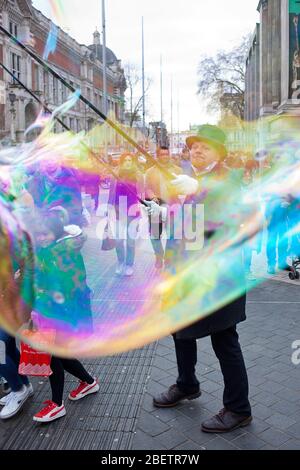 Street performer blowing giant soap bubbles Stock Photo