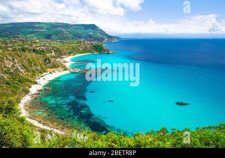 Aerial amazing tropical view of turquoise gulf bay, sandy beach, green mountains and plants, blue sky white clouds background from cliffs platform Cap Stock Photo