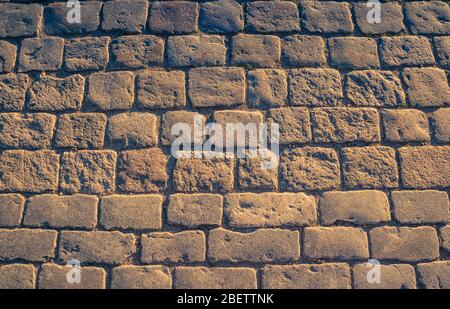 Cobblestone pavement background with copy space. Abstract old close-up cobble stone texture. Pavingstone patterned street view from above, paving tile Stock Photo