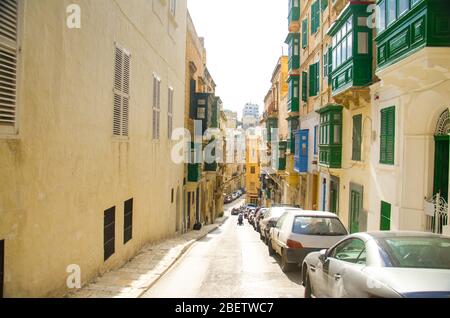 Top view of narrow streets and yellow buildings with colorful balconies and windows in Valletta, Malta Stock Photo