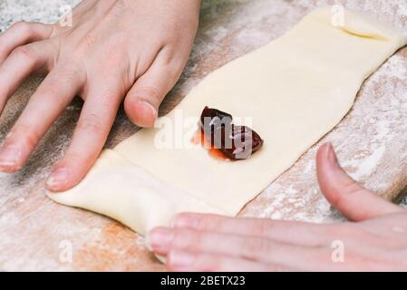 Dough and jam on a wooden board. Making baked pastry Stock Photo