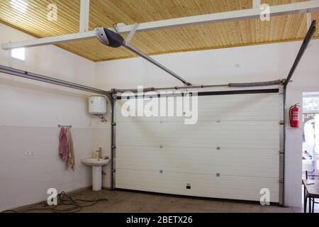 Shutter door or roller door and concrete floor outside .White Automatic shutters in a house . gates in the garage . Automatic Electric Roll-up Gate Or Stock Photo