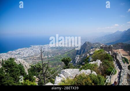 View of Kyrenia Girne mountains and town from medieval Saint Hilarion Castle in front of blue sky with white clouds and Mediterranean sea, Northern Cy Stock Photo