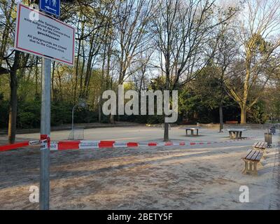 Empty, abandoned athletic ground park with basketball basket court & table tennis closed by police barrier tape & warning sign - corona virus covid-19 Stock Photo