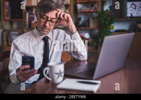 businessman working in smart working from home, thoughtful expression and worried about the future while looking at news, stock market trends, message Stock Photo