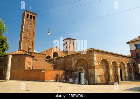 Basilica of Sant'Ambrogio church brick building with bell towers and The Devil's column on square, Milan, Lombardy, Italy Stock Photo