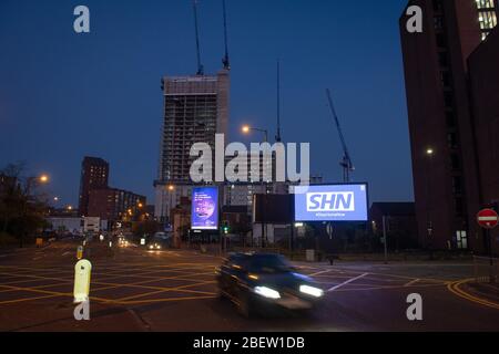 MANCHESTER, UK A billboard with the NHS logo rotated 180 degrees to warn motorists to STAY HOME NOW on Great Ancoats Street at twilight in Manchester city centre on Wednesday 15th April 2020. (Credit: Pat Scaasi | MI News) Credit: MI News & Sport /Alamy Live News Stock Photo