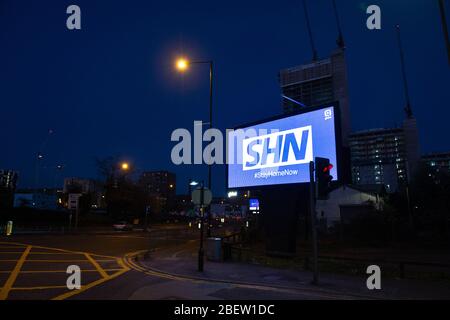 MANCHESTER, UK A billboard with the NHS logo rotated 180 degrees to warn motorists to STAY HOME NOW on Great Ancoats Street at twilight in Manchester city centre on Wednesday 15th April 2020. (Credit: Pat Scaasi | MI News) Credit: MI News & Sport /Alamy Live News Stock Photo