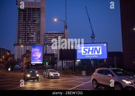 MANCHESTER, UK A billboard with the NHS logo rotated 180 degrees to warn motorists to STAY HOME NOW on Great Ancoats Street at twilight in Manchester city centre on Wednesday 15th April 2020. (Credit: Pat Scaasi | MI News) Credit: MI News & Sport /Alamy Live News Stock Photo