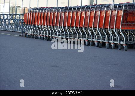 a row of empty trolleys and empty bike rack in front of closed store. They are symbol of coronavirus, COVID-19 measures, such as lockdown, quarantine, Stock Photo