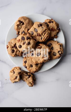 Overhead close up of freshly baked chocolate chip cookies on a plate. Stock Photo