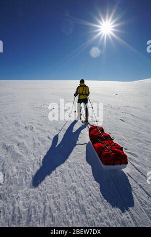 man dragging expedition sled on large snowfield on Langjokull glacier Stock Photo
