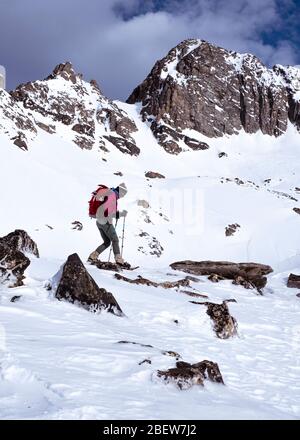 Woman snowshoe hiking in snow covered mountains in winter in Montana Stock Photo