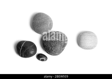Scattered sea pebbles. Smooth gray and black stones isolated on white background. Top view Stock Photo
