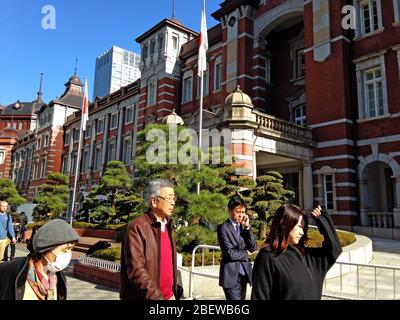Pedestrians pass the historic and iconic Tokyo Train Station Marunouchi building in the Marunouchi business district of Tokyo, Japan. Stock Photo