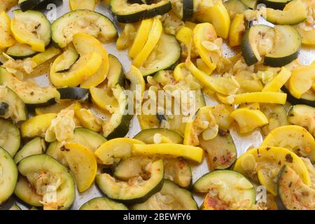 Zucchini and yellow summer crookneck squash slices on aluminum foil in baking pan sheet Stock Photo