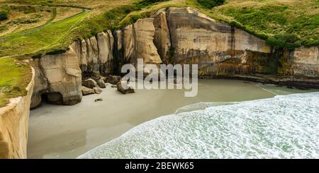Tunnel Beach surrounded by into the sandstone cliffs near Dunedin New Zealand Stock Photo