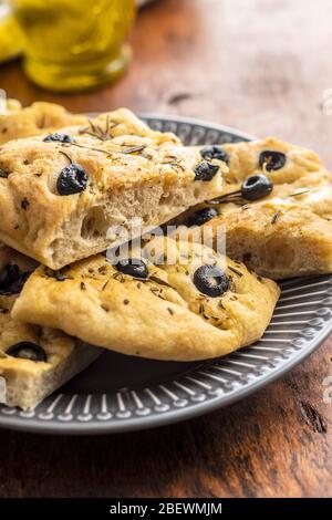 Homemade Italian Focaccia. Traditional Italian pastries with olives on wooden table. Stock Photo