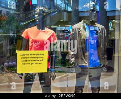 Closed sign in German script in a shop with mannequins. Recommendation of our federal government. Stock Photo