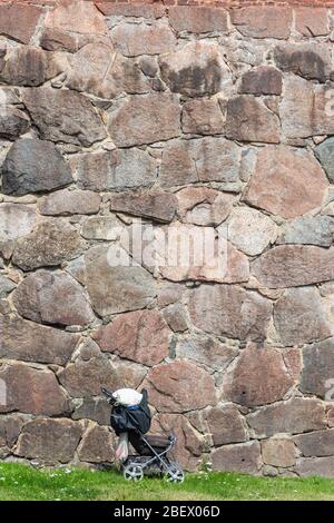 Baby carriage at old stone wall in Hämeenlinna Finland Stock Photo
