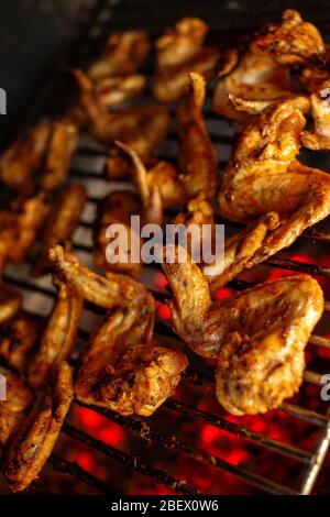 Grilled spicy chicken wings. Marinated chicken meat roasted on a grill. Delicious party snack. Shallow depth of field Stock Photo