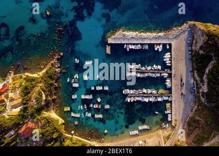 Aerial of boats in harbour on a greek island Corfu. Paleokastritsa port shot from a drone. Greece travel destinations Stock Photo