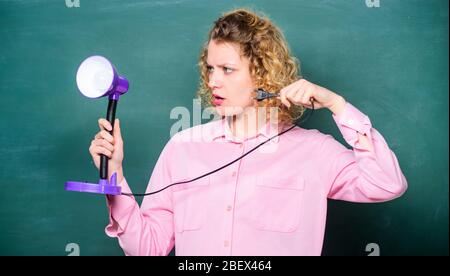 Insight and idea. Educational idea. Woman work on bright shiny idea. Creativity and inspiration. Teacher hold table lamp in hand chalkboard background. Knowledge day. Light up process of studying. Stock Photo