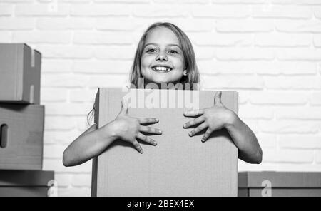 Packaging things. Move out concept. Delivering your purchase. Kid moving out. Moving routine. Prepare for moving. Rent house. Real estate. Make moving easier. Girl small child carry cardboard box. Stock Photo