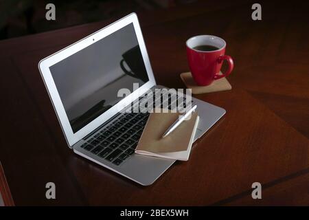 Laptop with notepad and coffee on wood table. Copy space. Stock Photo