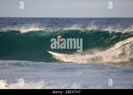 During COVID-19 pandemic young australian man surfing board riding at Avalon Beach in Sydney to get his daily exercise Stock Photo