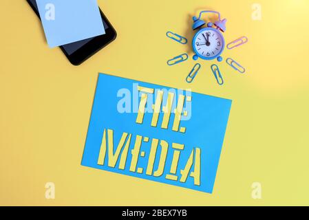 Handwriting text The Media. Conceptual photo main means of mass communication that are regarded collectively Smartphone metal alarm clock clips paper Stock Photo