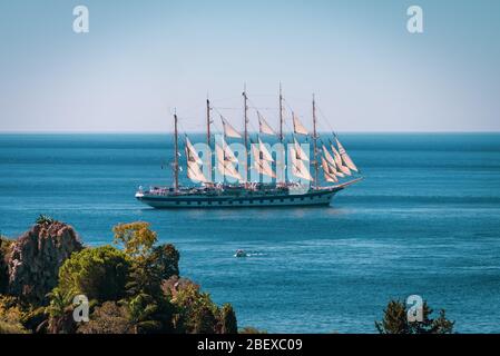 Beautiful old ship with many sails floating in the Mediterranean Sea near Isola Bella Nature Reserve, Taormina, Sicily, Stock Photo