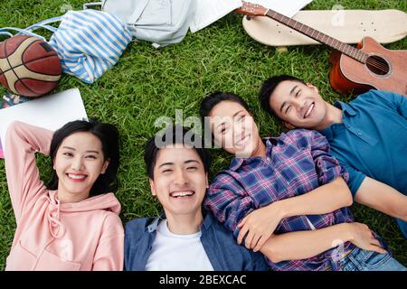 Happy students lay on the grass Stock Photo