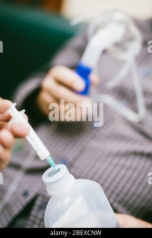 Preparation of compressor nebulizer for use on senior man with respiratory mask, nebulizer in the room Stock Photo