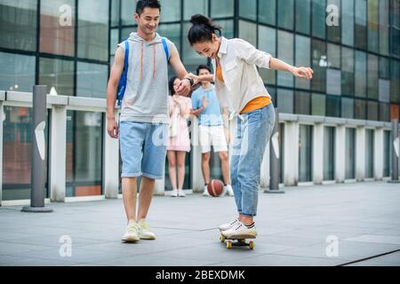 Handsome students goddaughter friend skateboarding Stock Photo