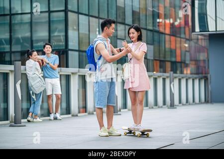 Handsome students goddaughter friend skateboarding Stock Photo