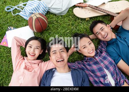 Happy students lay on the grass Stock Photo