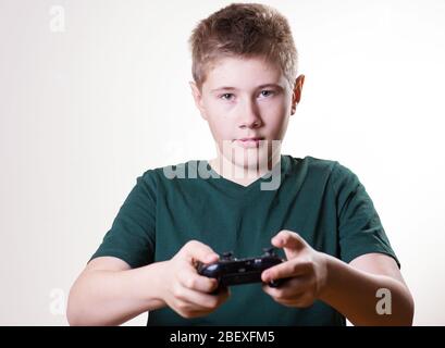 concentrated boy with gamepad. teenager holding video game controller and playing Stock Photo
