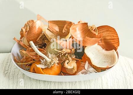 Onion peel, coffee grounds, tea bags and garlic stem, orange peel in white bowl against white background. Concept composting, Eco-friendly, recycling. Stock Photo