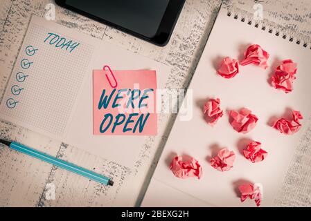 Handwriting text We Re Open. Conceptual photo answering on client that shop is available at this time Squared spiral notebook marker smartphone paper Stock Photo