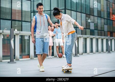 Handsome students goddaughter friend skateboarding Stock Photo
