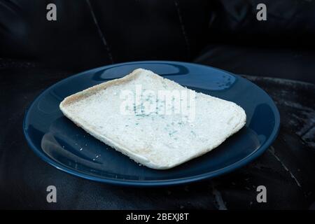 Slice of white bread with green mould growing on it. Stock Photo