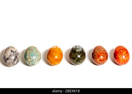 Natural multicolored stone eggs on white background Stock Photo