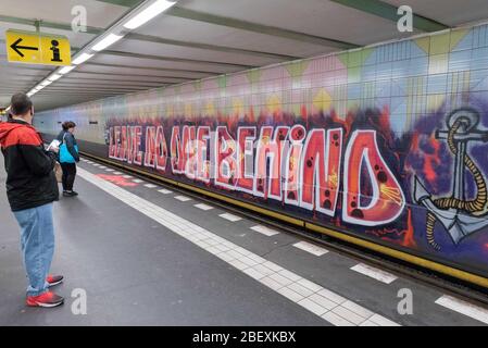 April 16, 2020: People can be seen next to a large graffiti by the artist group 1UP with the text 'Leave no one behind' on the wall of the underground station KurfuerstenstraÃŸe in Berlin. The hashtag used is recalling the debate about the politics, practices and events surrounding the European border regime and about migration movements and is often used by groups advocating humanitarian rights for refugees. Credit: Jan Scheunert/ZUMA Wire/Alamy Live News Stock Photo