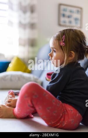 Two year old girl with big eyas portrait, Indoor shoot with natural light Stock Photo